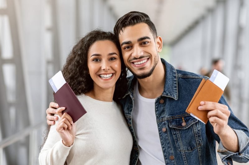 Happy Travellers. Portrait Of Young Arab Couple With Passports And Tickets Posing At Airport, Cheerful Smiling Middle Eastern Spouses Enjoying Travelling Together, Ready For Vacation Trip, Closeup